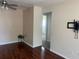 Living room with ceiling fan and wood-look floors, with an adjacent room visible through a doorway at 5335 Embassy Ave # 5335, New Port Richey, FL 34652