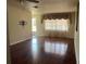 Bright living room with hardwood floors, large window with drapes, and a ceiling fan at 5335 Embassy Ave # 5335, New Port Richey, FL 34652