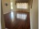 Inviting living room featuring hardwood floors, a well-lit window, and easy access to the front door at 5335 Embassy Ave # 5335, New Port Richey, FL 34652