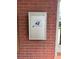 A wall-mounted US Postal Service mailbox is mounted to a red brick wall near a residential unit's entry at 5335 Embassy Ave # 5335, New Port Richey, FL 34652