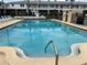 Inviting community pool with clear water, lounge chairs, and building in the background, perfect for relaxation at 5335 Embassy Ave # 5335, New Port Richey, FL 34652