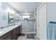 Bright bathroom featuring double vanity, glass shower with stone pebble floor at 5342 Leisure St, Dade City, FL 33523