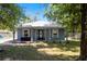 Charming single-story home with a white metal roof, blue-gray siding, and a well-maintained front yard at 5342 Leisure St, Dade City, FL 33523