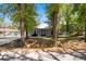 A cozy home with a neatly kept lawn, featuring mature trees and a welcoming front porch and a metal roof at 5342 Leisure St, Dade City, FL 33523