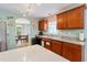 Well-lit kitchen featuring wood cabinets, granite countertops, stainless steel appliances, and view to dining area at 5342 Leisure St, Dade City, FL 33523