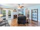 Cozy living room features hardwood floors, neutral walls, ceiling fan, and large glass doors to screened lanai at 5342 Leisure St, Dade City, FL 33523