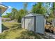 Backyard featuring a metal storage shed and tools, enclosed within a secure chain-link fence at 5342 Leisure St, Dade City, FL 33523