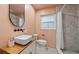 Bathroom featuring a modern vanity, stylish mirror, and tiled shower with decorative leaf pattern for a spa-like feel at 5417 Carlton Rd, New Port Richey, FL 34652