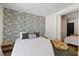 Stylishly decorated bedroom featuring a patterned wallpaper, hardwood flooring, and walk-in closet at 5417 Carlton Rd, New Port Richey, FL 34652