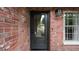 Charming brick home featuring a stylish black front door with glass window and modern light fixture at 5417 Carlton Rd, New Port Richey, FL 34652