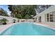 Large, inviting pool surrounded by a concrete deck and lush landscaping, perfect for outdoor relaxation at 5417 Carlton Rd, New Port Richey, FL 34652