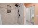 Stylish shower showcasing a modern black shower-head, a tiled wall, and adjacent doorway for easy access at 5417 Carlton Rd, New Port Richey, FL 34652