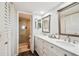 Bathroom featuring double sinks, wood-framed mirrors, and a glass-enclosed shower at 5537 Sea Forest Dr # 301, New Port Richey, FL 34652