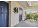 Hallway outside unit 301, features a decorated door, seating area, and a glimpse of the outdoors at 5537 Sea Forest Dr # 301, New Port Richey, FL 34652