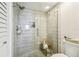 Walk-in shower features neutral tile, a glass enclosure, a shower head, and built-in shelving at 5537 Sea Forest Dr # 301, New Port Richey, FL 34652