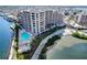 Stunning aerial view of waterfront condo building with pool, beach access, and lush landscaping at 6035 Sea Ranch Dr # 305, Hudson, FL 34667