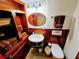 Cozy bathroom with wood fixtures featuring a pedestal sink, wood shelving, and a medicine cabinet with an oval mirror at 6035 Sea Ranch Dr # 305, Hudson, FL 34667