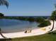 Beautiful beach view with lounge chairs and calm water at 6035 Sea Ranch Dr # 305, Hudson, FL 34667