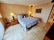 Cozy bedroom features tiled floors, decorative lamps, and a patterned duvet at 6035 Sea Ranch Dr # 305, Hudson, FL 34667