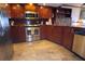 Kitchen area features stainless steel appliances, wood cabinets, and travertine floors at 6035 Sea Ranch Dr # 305, Hudson, FL 34667