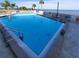 Community pool with clear blue water and lounge chairs, overlooking the ocean at 6035 Sea Ranch Dr # 305, Hudson, FL 34667