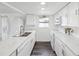 Bright kitchen featuring white cabinetry, modern appliances, marble countertops, and wood-look flooring at 6422 Tralee Ave, New Port Richey, FL 34653