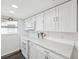 Modern kitchen with white cabinets, quartz countertops, and stainless steel appliances at 6422 Tralee Ave, New Port Richey, FL 34653