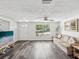 Bright living room features wood-look flooring, a large window and a comfortable sofa and decor at 6422 Tralee Ave, New Port Richey, FL 34653