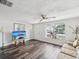 Bright living room features wood-look flooring, a large window and a comfortable sofa and decor at 6422 Tralee Ave, New Port Richey, FL 34653