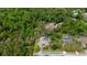 An aerial view highlights the property with mature trees surrounding the home and screened-in pool at 6475 Laurel Oak Dr, Spring Hill, FL 34607