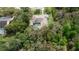 Aerial view of home featuring a private screened in swimming pool surrounded by dense foliage at 6475 Laurel Oak Dr, Spring Hill, FL 34607