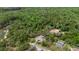 An aerial view highlights the property with mature trees surrounding the home and screened-in pool at 6475 Laurel Oak Dr, Spring Hill, FL 34607