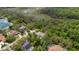 A scenic aerial view displays the home nestled among mature trees, featuring a screened-in pool and surrounding neighborhood at 6475 Laurel Oak Dr, Spring Hill, FL 34607