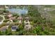Expansive aerial view of a neighborhood with lush greenery and a serene lake at 6475 Laurel Oak Dr, Spring Hill, FL 34607