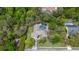 An aerial view showcases a beautiful home with a screened pool surrounded by lush greenery and mature trees at 6475 Laurel Oak Dr, Spring Hill, FL 34607