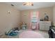 Light-filled bedroom with toys, a pink rug, and natural light streaming through the window at 6475 Laurel Oak Dr, Spring Hill, FL 34607
