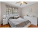 Comfortable bedroom with wood floors, ceiling fan, natural light, and decorative window dressings at 6475 Laurel Oak Dr, Spring Hill, FL 34607
