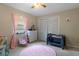 Cozy bedroom with a pink rug, a playpen, and natural light from the window at 6475 Laurel Oak Dr, Spring Hill, FL 34607
