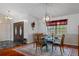 Dining room with light from a window, a glass table with seating for four, and an entryway with glass double doors at 6475 Laurel Oak Dr, Spring Hill, FL 34607