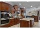 Gourmet kitchen featuring stainless steel appliances, granite countertops, custom wood cabinetry, and a central island at 6475 Laurel Oak Dr, Spring Hill, FL 34607