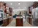Large, eat-in kitchen featuring granite countertops, stainless steel appliances, a center island, and rich wood cabinetry at 6475 Laurel Oak Dr, Spring Hill, FL 34607