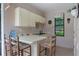 This outdoor kitchen boasts custom cabinets, a breakfast bar, and a window overlooking the yard at 6475 Laurel Oak Dr, Spring Hill, FL 34607