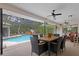 Covered outdoor patio with a dining set and seating area overlooking the pool and garden at 6475 Laurel Oak Dr, Spring Hill, FL 34607