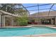 Relax in this large screened in pool with an outdoor seating area and colorful landscaping at 6475 Laurel Oak Dr, Spring Hill, FL 34607
