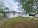 Back and side exterior view of the home with partially fenced yard at 6819 Treehaven Dr, Spring Hill, FL 34606