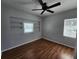 Cozy bedroom with wood laminate floors, a ceiling fan, and built-in shelving at 6819 Treehaven Dr, Spring Hill, FL 34606