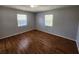 Bright bedroom with two windows offering natural light and wood-look laminate flooring at 6819 Treehaven Dr, Spring Hill, FL 34606