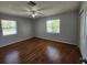 Spacious bedroom featuring neutral walls, ceiling fan and wood-look laminate flooring at 6819 Treehaven Dr, Spring Hill, FL 34606