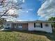 Charming single-story home with a brick accent, manicured lawn, and mature tree at 6819 Treehaven Dr, Spring Hill, FL 34606
