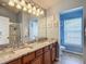 Bright bathroom featuring double sinks, granite countertop, a doorway, and a glass enclosed shower at 6821 Breezy Palm Dr, Riverview, FL 33578